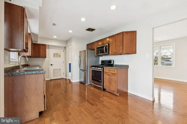 a kitchen with stainless steel appliances granite countertop a stove a sink and a refrigerator