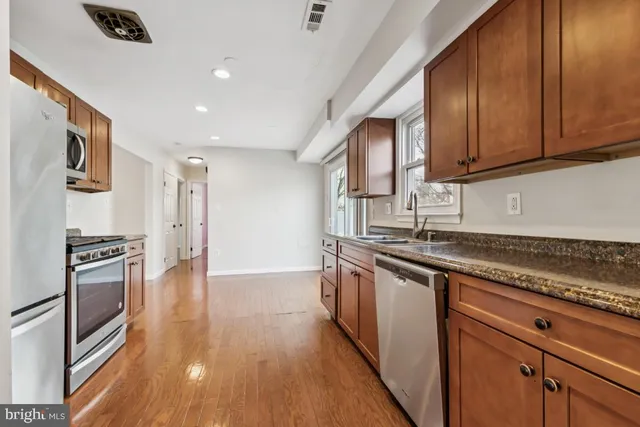 a kitchen with stainless steel appliances granite countertop a stove and a sink