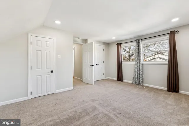 an empty room with windows and closet area