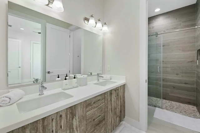 a bathroom with a double vanity sink mirror and shower