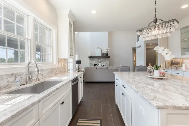 a living room with furniture a fireplace and a chandelier