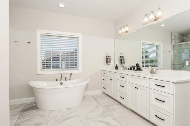 a bedroom with a large bed and a chandelier fan