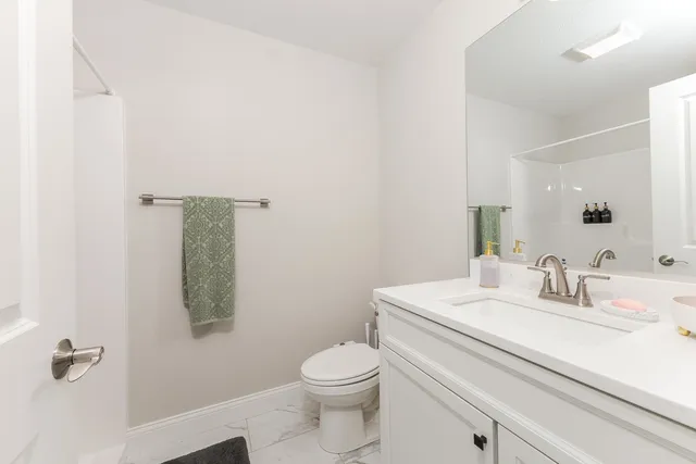 a bathroom with a granite countertop sink toilet and shower