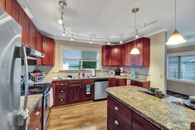 a kitchen with kitchen island granite countertop a sink cabinets and window