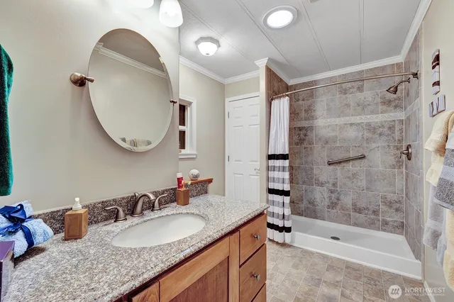 a bathroom with a granite countertop sink mirror and shower