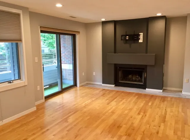 a view of an empty room with window and fire place