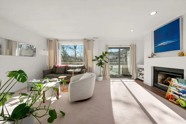 a living room with furniture a fireplace and a floor to ceiling window