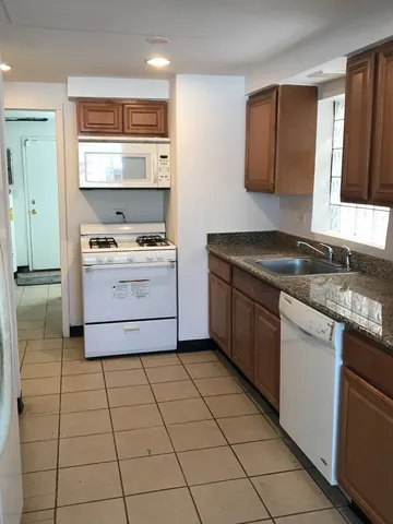 a kitchen with a stove sink and cabinets