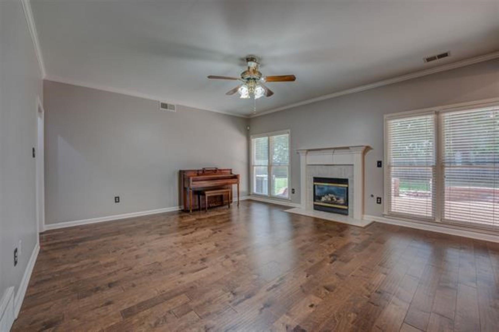 1189 Macon Ridge Drive Collierville, TN 38017 - Photo 5 of 22 a view of a livingroom with a fireplace a ceiling fan and windows