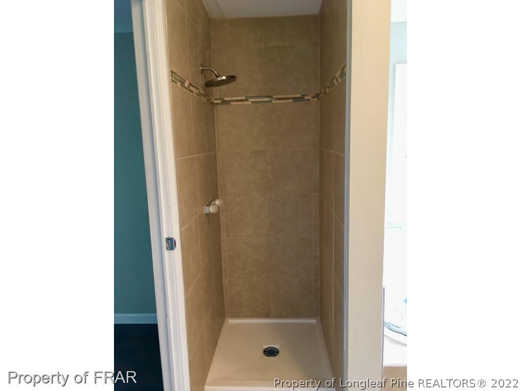 7692 Smithfield Road Godwin, NC 28344 - Photo 25 of 36 a bathroom with a glass door shower