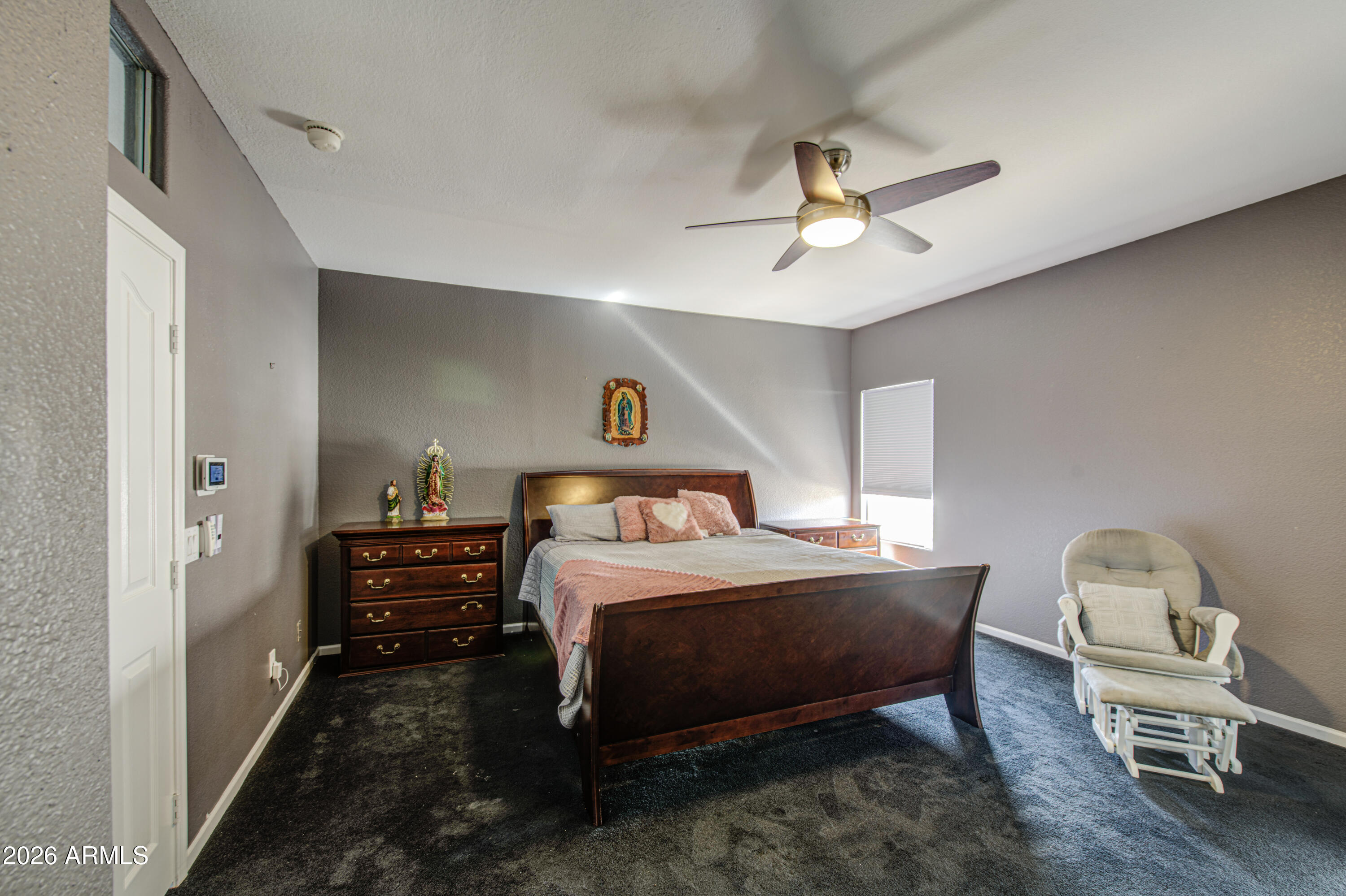 12403 West Monte Vista Road Avondale, AZ 85392 - Photo 28 of 63 a bedroom with a bed and a chair
