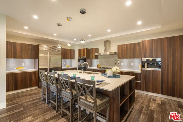 a kitchen with a dining table chairs appliances and cabinets