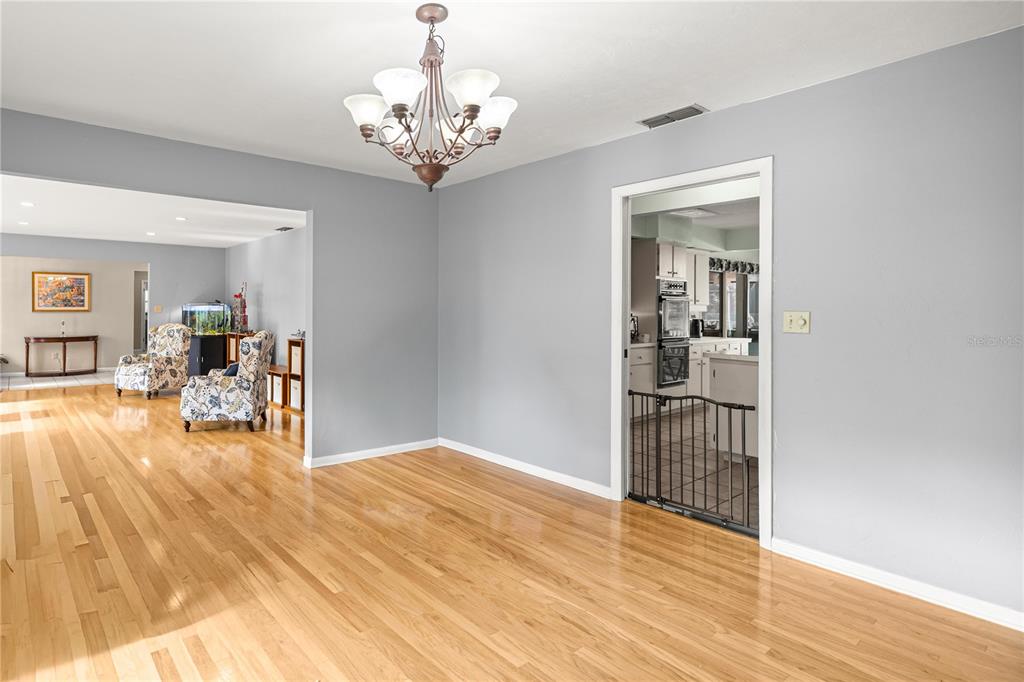 9825 Southwest 202nd Avenue Road Dunnellon, FL 34431 - Photo 19 of 69 a view of a livingroom with wooden floor and a chandelier
