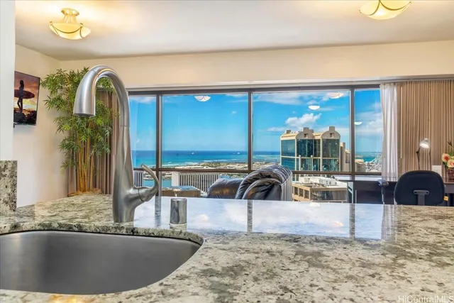 a view of a kitchen with a sink and living area