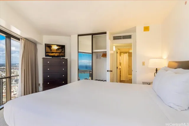 a bedroom with a bed and a tv on dresser