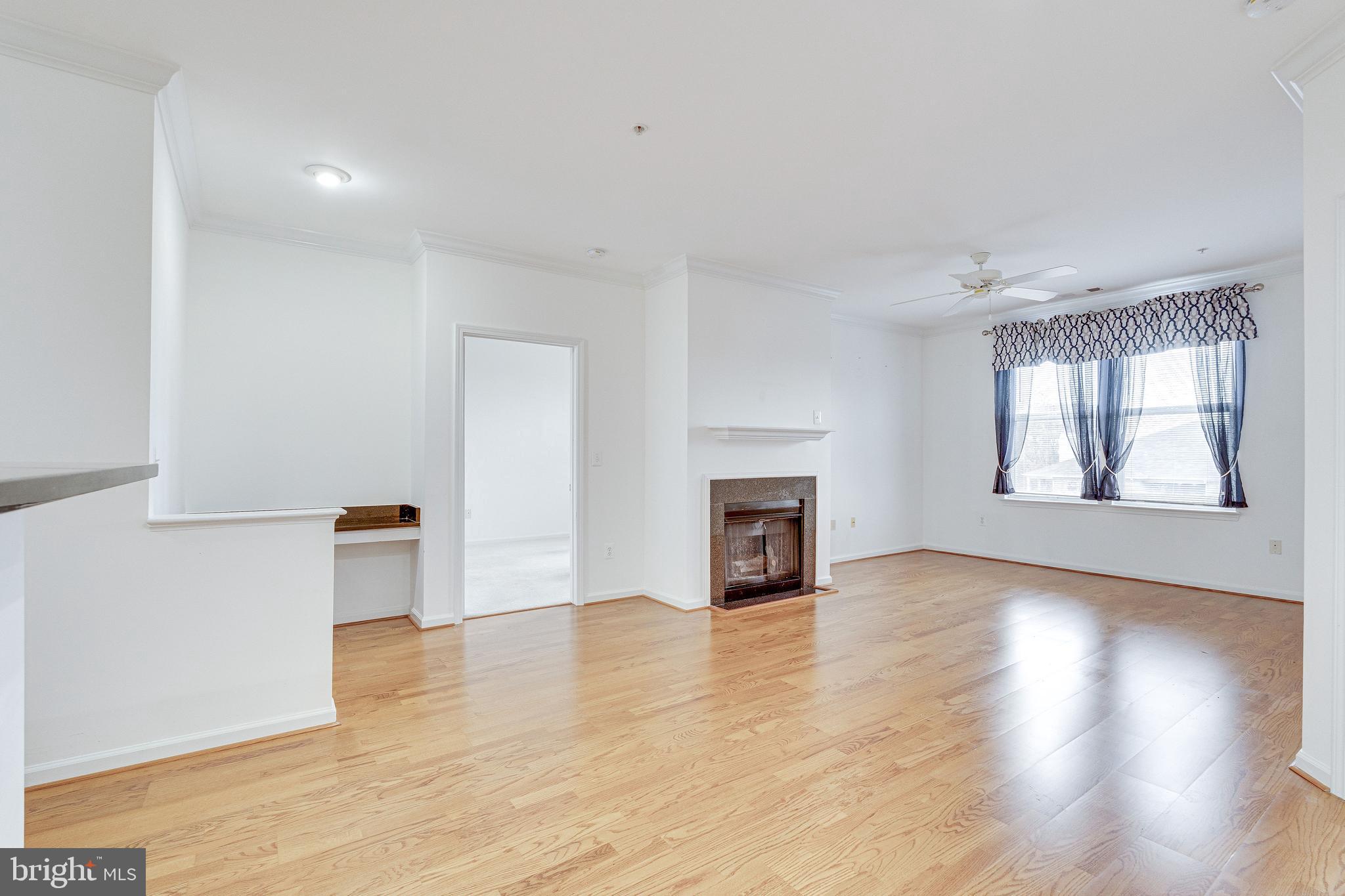 12000 Market Street, Unit 370 Reston, VA 20190 - Photo 15 of 51 an empty room with wooden floor fireplace and windows