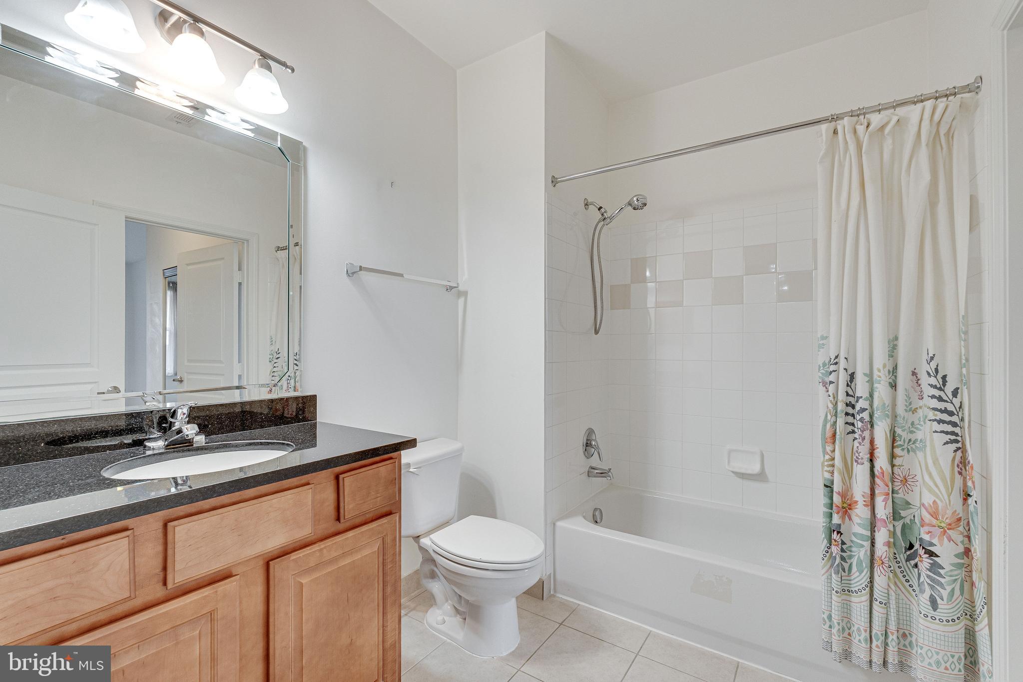 12000 Market Street, Unit 370 Reston, VA 20190 - Photo 23 of 35 a bathroom with a granite countertop sink a toilet and shower
