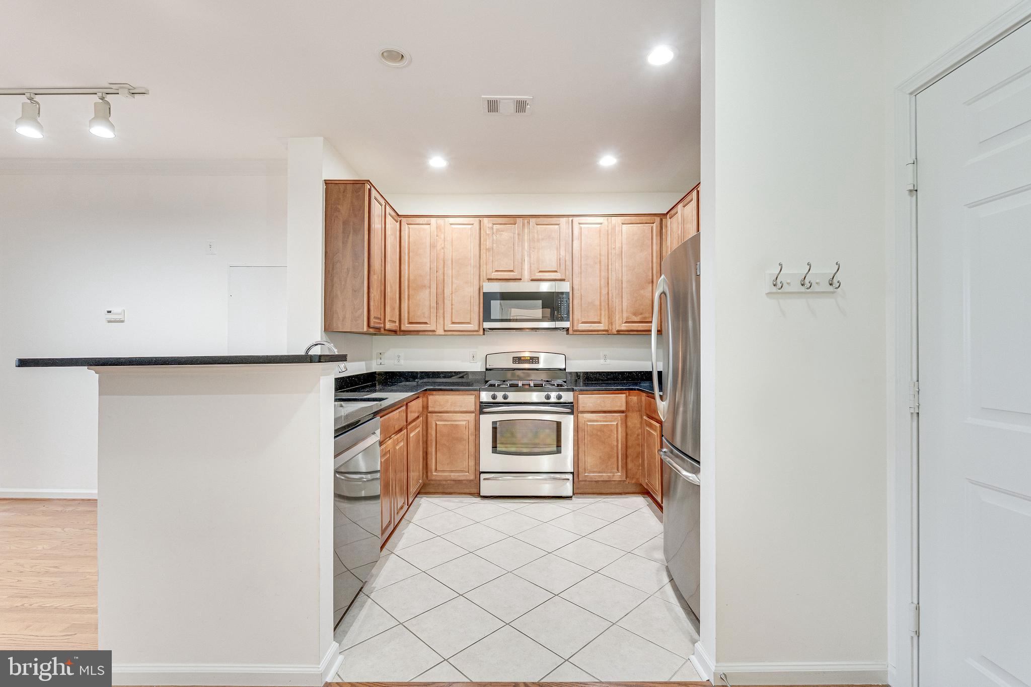12000 Market Street, Unit 370 Reston, VA 20190 - Photo 5 of 51 a kitchen with stainless steel appliances granite countertop a refrigerator and a stove top oven
