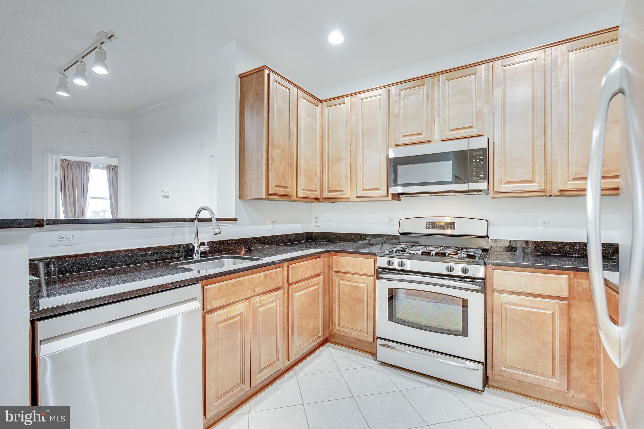 12000 Market Street, Unit 370 Reston, VA 20190 - Photo 6 of 51 a kitchen with granite countertop white cabinets and white appliances