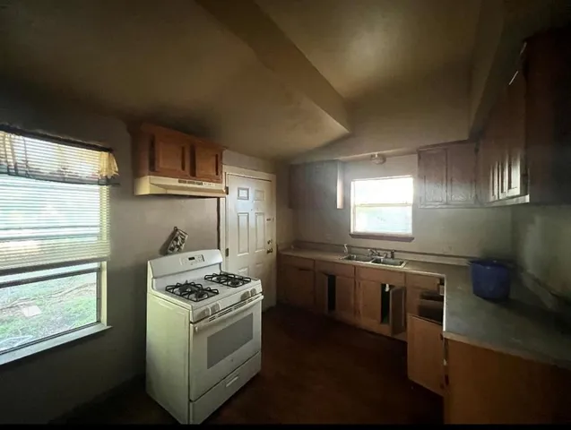 a kitchen with stainless steel appliances granite countertop a stove a sink and a refrigerator