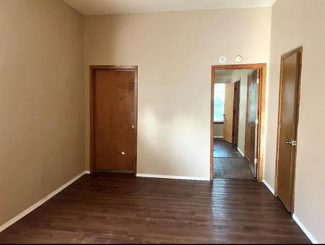 a view of a hallway with wooden floor and closet