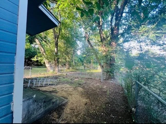 a view of a backyard with large trees