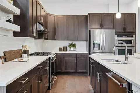 a kitchen with kitchen island granite countertop a sink stove and refrigerator