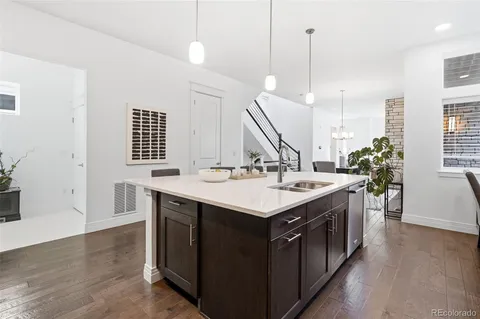 a kitchen with a sink a stove and a wooden floor