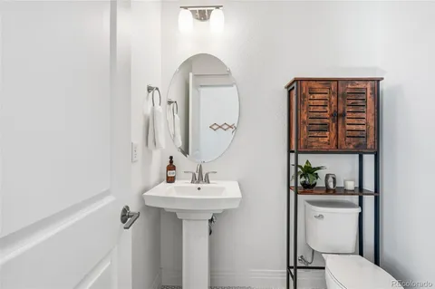 a bathroom with a sink toilet and a mirror