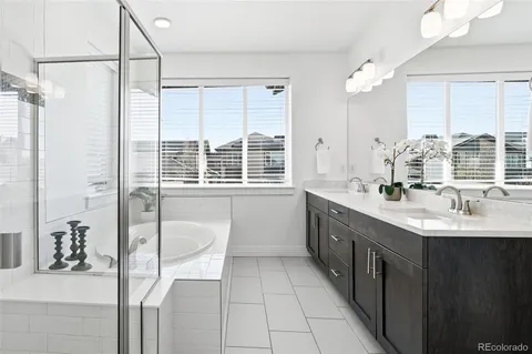 a spacious bathroom with a double vanity sink a mirror and a shower