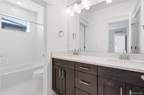 a bathroom with a granite countertop sink a toilet and shower