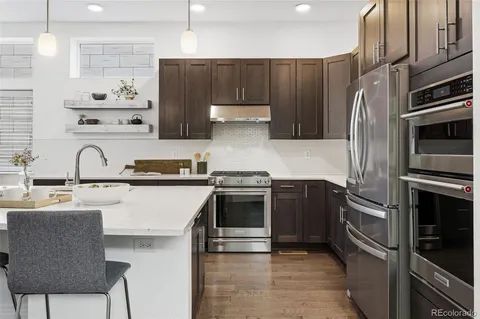 a kitchen with kitchen island a stove and a refrigerator