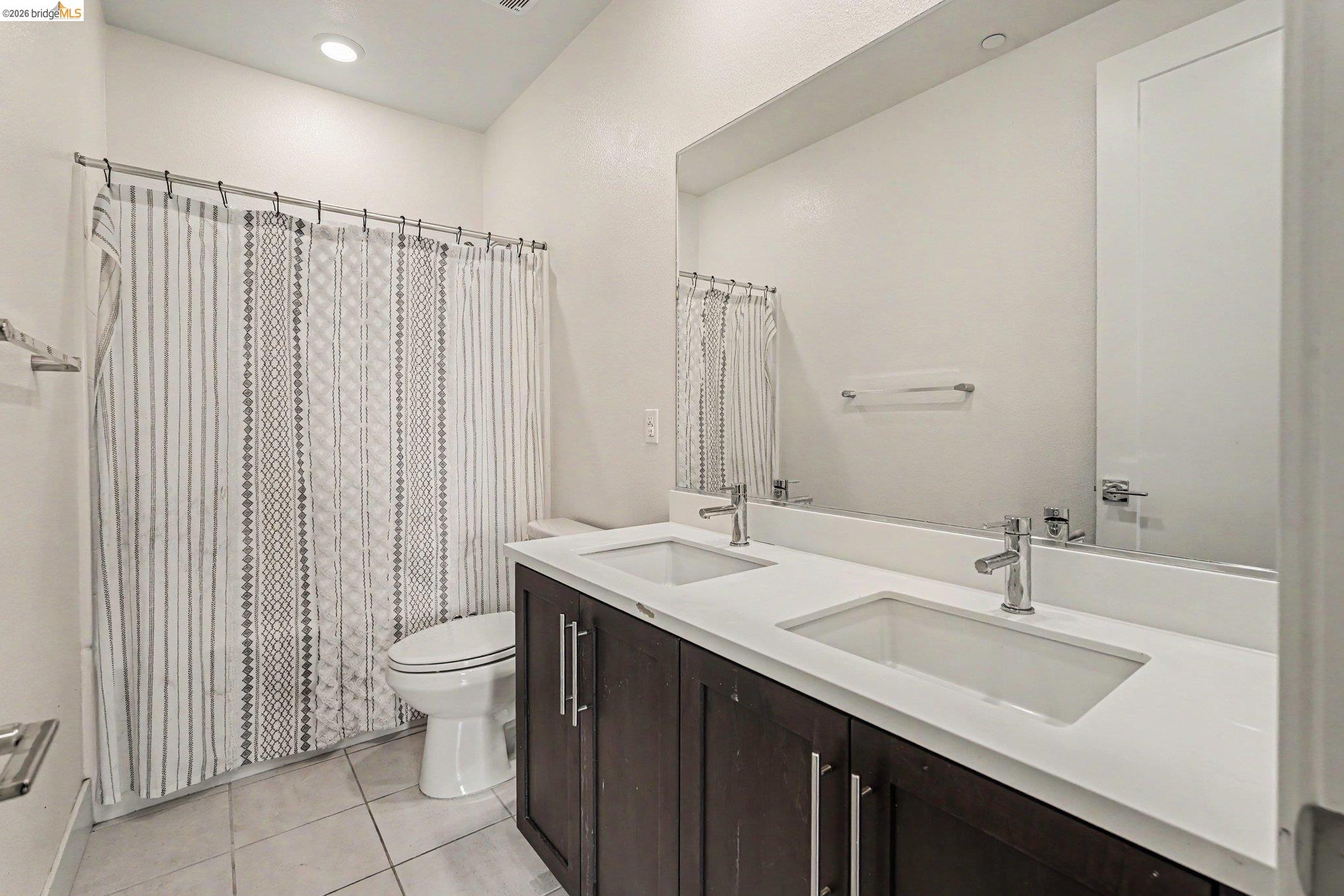 18210 Argento Loop San Ramon, CA 94583 - Photo 15 of 43 Dual vanity with under-mount sinks, a wide mirror, and dark wood-finish cabinetry