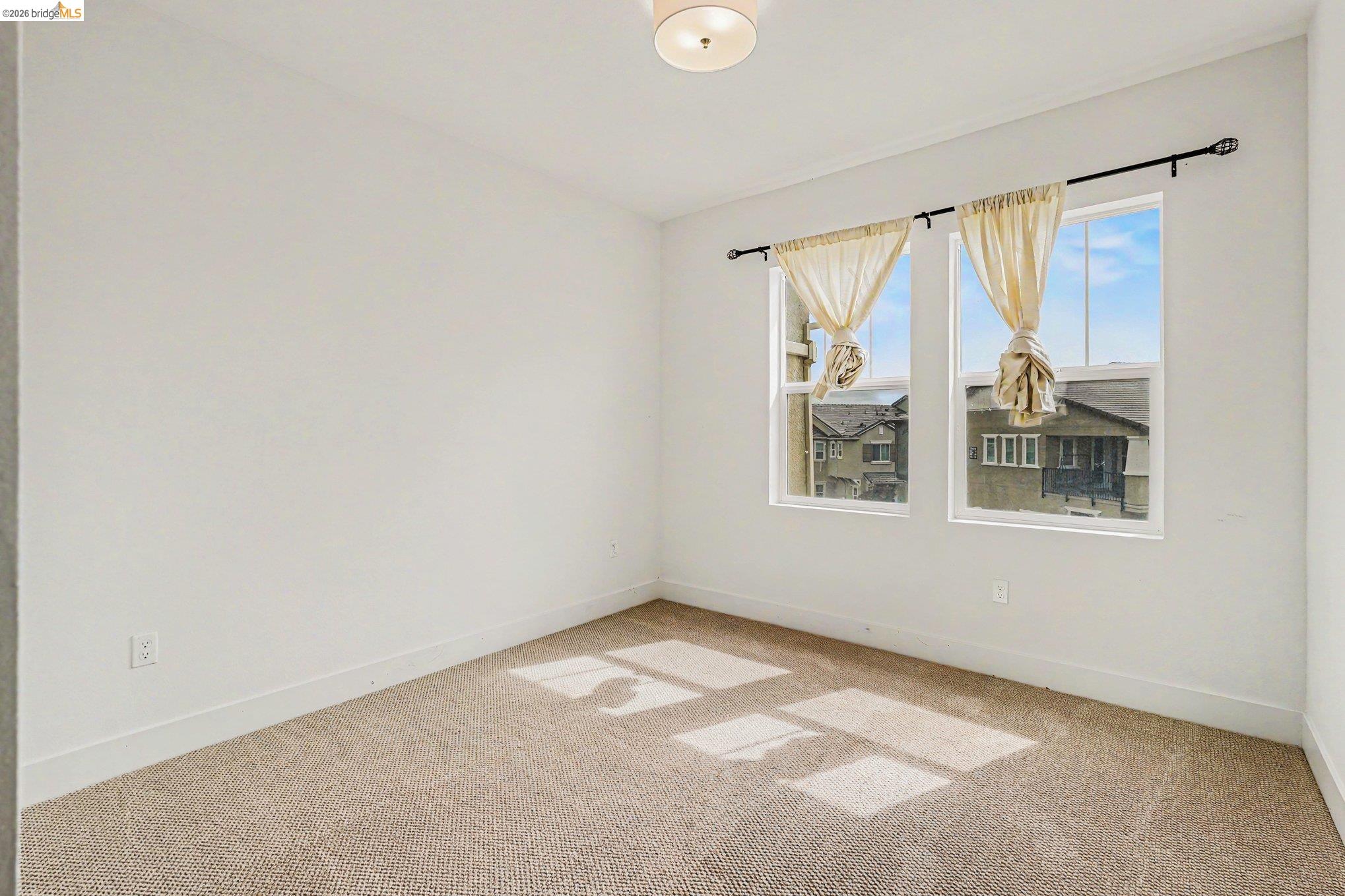 18210 Argento Loop San Ramon, CA 94583 - Photo 29 of 43 Bright interior space featuring a textured carpet floor, white baseboards, and a pair of double-hung windows