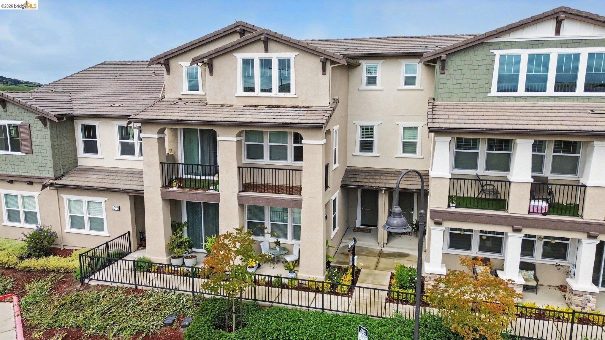 18210 Argento Loop San Ramon, CA 94583 - Photo 3 of 43 Contemporary multi-story townhome featuring a stucco and shingle exterior, private balconies, a fenced patio, and varied rooflines