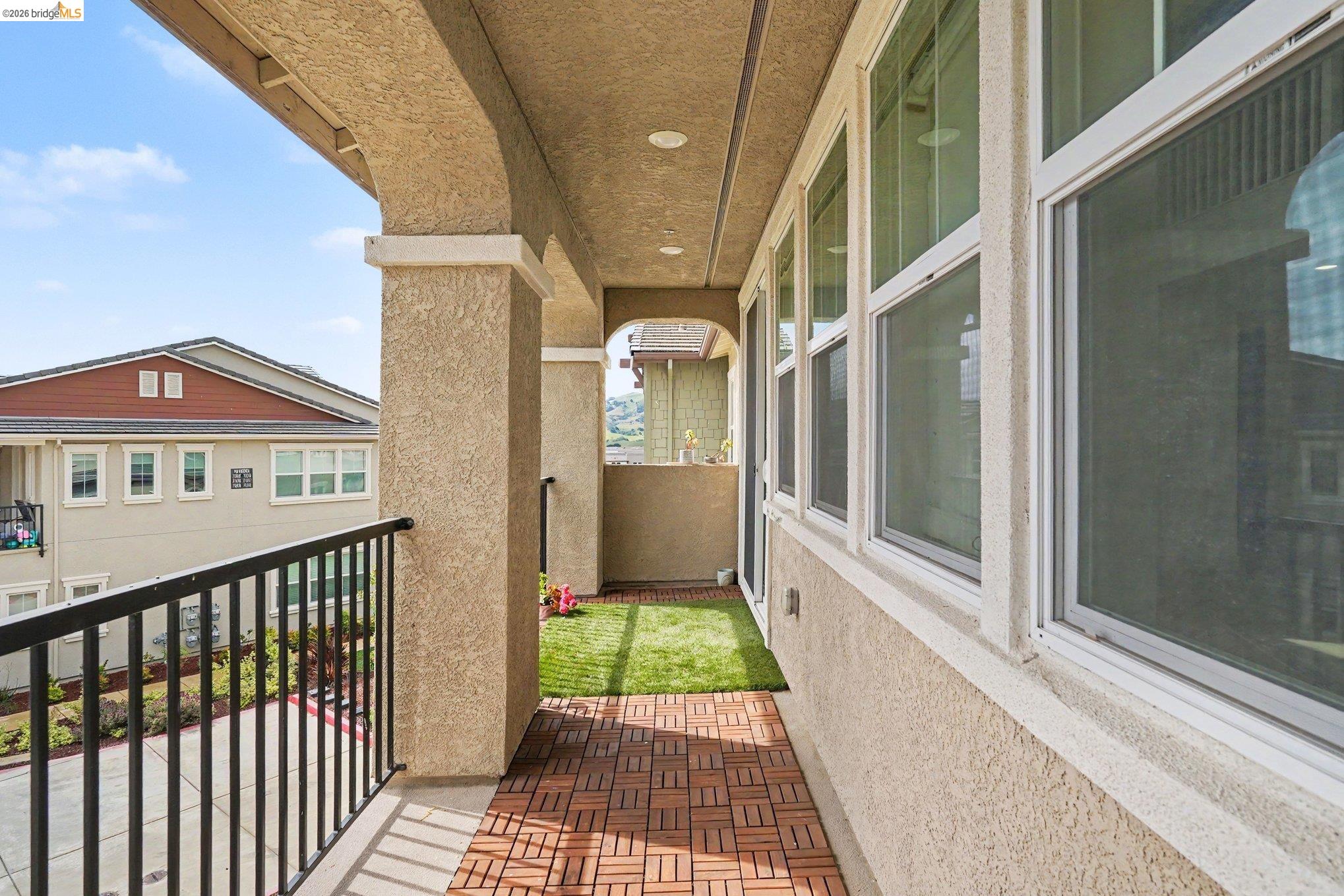 18210 Argento Loop San Ramon, CA 94583 - Photo 34 of 43 Covered outdoor balcony featuring archways, a black metal railing, and wood-finish tile flooring