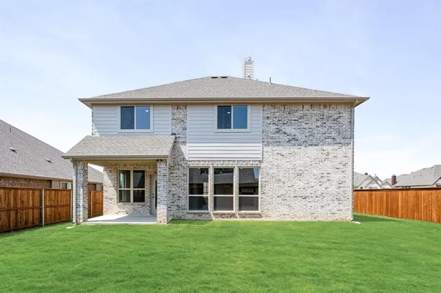 a view of a house with a big yard and a large tree