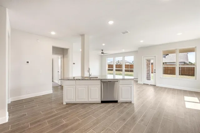 a large kitchen with stainless steel appliances granite countertop a large stove a sink dishwasher and a refrigerator with wooden floor