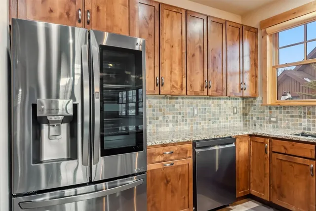 a kitchen with stainless steel appliances granite countertop a refrigerator and a sink