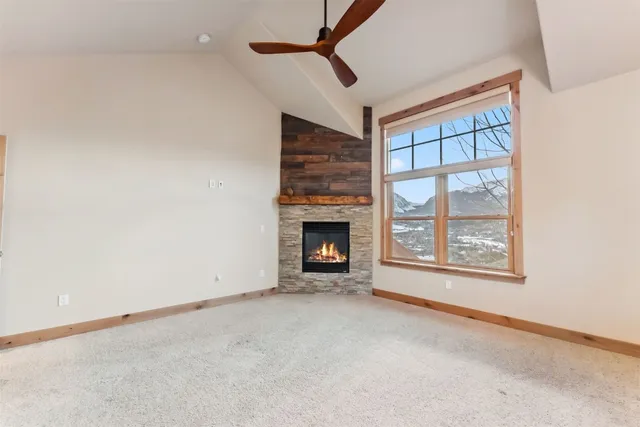 an empty room with windows and fireplace