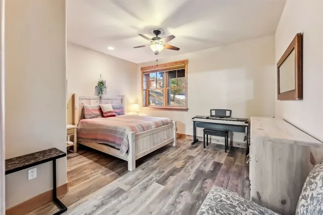 a bedroom with a bed table and two window