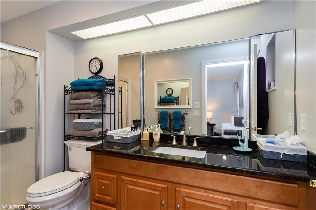 787 Palm View Drive, Unit 3 Naples, FL 34110 - Photo 12 of 19 a bathroom with a granite countertop sink a toilet and a mirror