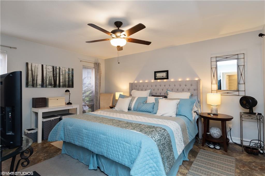 787 Palm View Drive, Unit 3 Naples, FL 34110 - Photo 13 of 19 a bedroom with a bed and a chandelier
