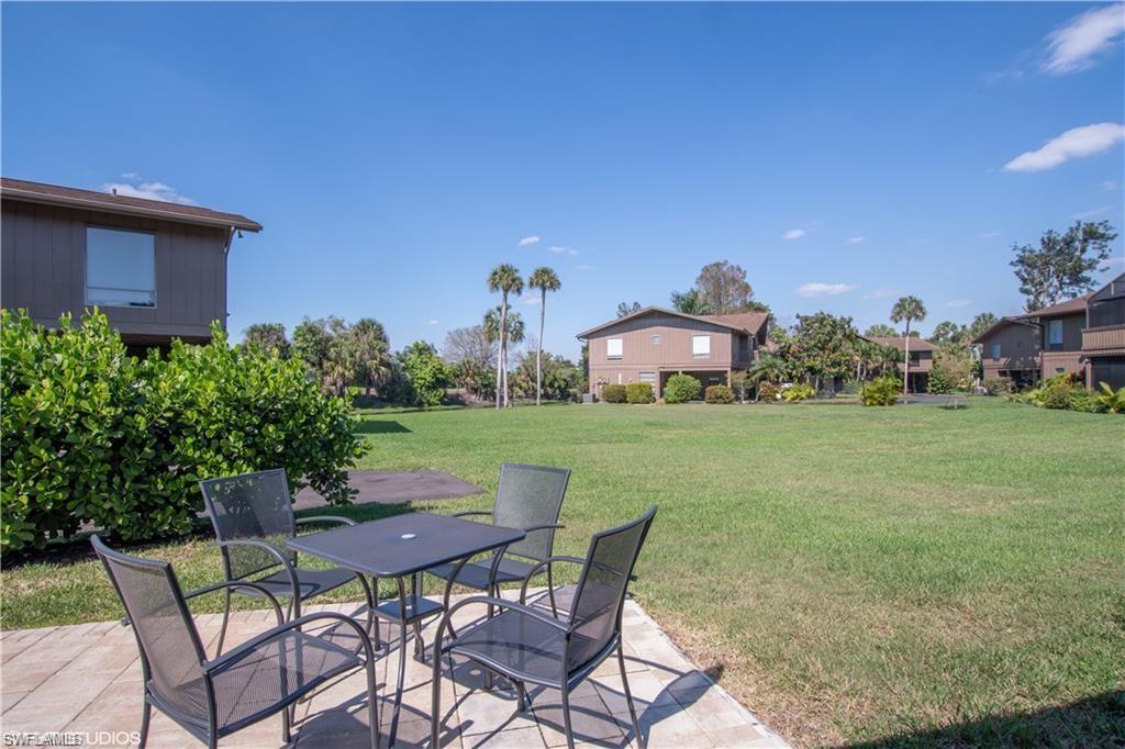 787 Palm View Drive, Unit 3 Naples, FL 34110 - Photo 17 of 19 a view of house with backyard outdoor seating and green space
