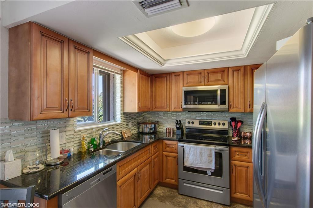 787 Palm View Drive, Unit 3 Naples, FL 34110 - Photo 8 of 19 a kitchen with stainless steel appliances granite countertop a stove a sink dishwasher and a refrigerator