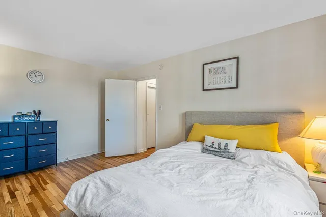 a bedroom with a bed and a lamp on dresser