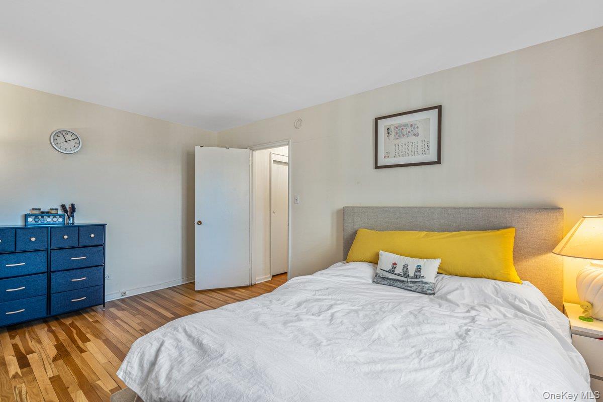 18-50 211th Street, Unit 6B Queens, NY 11360 - Photo 11 of 15 a bedroom with a bed and a lamp on dresser