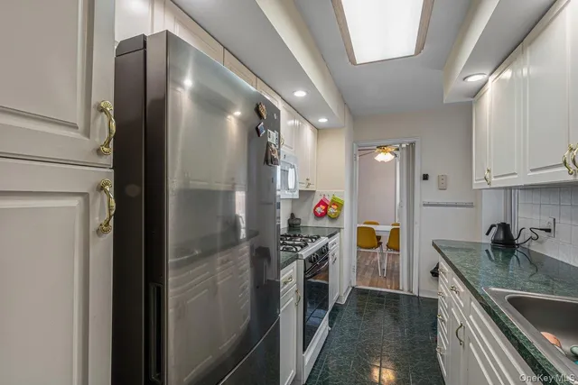 a kitchen with stainless steel appliances granite countertop a refrigerator and a sink
