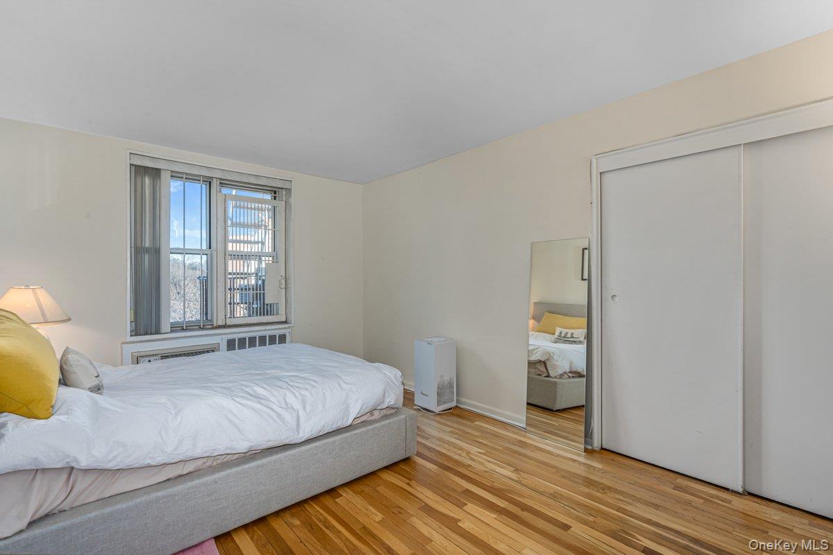18-50 211th Street, Unit 6B Queens, NY 11360 - Photo 9 of 15 a bedroom with a bed and wooden floor