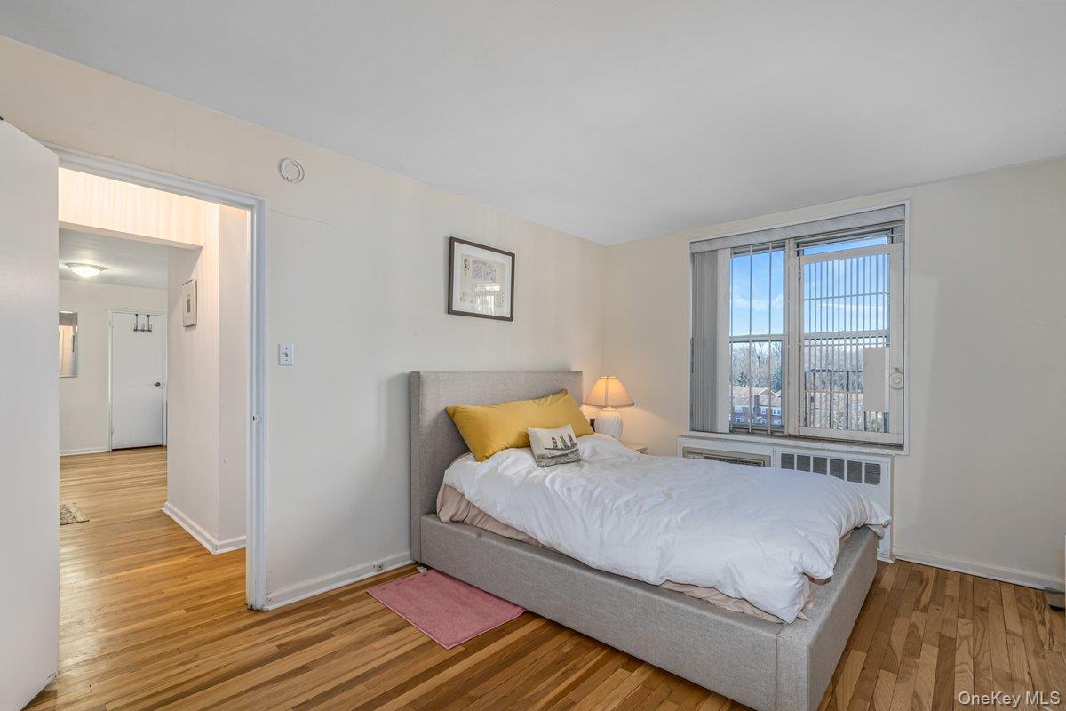 18-50 211th Street, Unit 6B Queens, NY 11360 - Photo 10 of 15 a bedroom with a bed and wooden floor